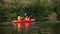 Kayak with a guy and a girl swims on the river. Slow motion