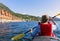 Kayak River Trip in Norway.  blonde girl in the red Kayak Paddling and Enjoying the Moment. Scenic Landscape