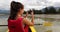 Kayak. Woman using phone taking pictures kayaking in Squamish Estuary surrounded by mountains relaxing enjoying