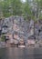 Kayaker dwarfed by huge granite cliff