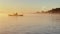 Kayaker floats on calm water through the morning fog above the water at sunrise, the silhouette of a man with a paddle