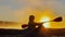 Kayaker floats on calm water through the morning fog above the water at sunrise, the silhouette of a man with a paddle