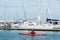 Kayaker paddling past Royal Brighton Yacht Club Marina in Melbourne.