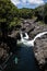 Kayaker paddling upstream in green kayak on river