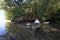 Kayaker resting amidst mangrove trees.