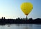 Kayaker watching a big yellow hot air balloon