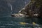 Kayakers enjoy the scenery and waterfalls of Milford Sound, one of New Zealand`s most popular tourist destinations