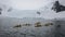 Kayakers gather by an ice-capped mountain range