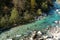 Kayakers paddling on the clear turquoise waters of the Soca River in the mountains of northern Slovenia