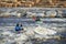 Kayakers surfing a wave in the Poudre River Whitewater Park