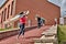 Kayakers walk upstairs with kayaks on shoulders after rowing training.