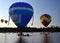 Kayakers watching big colourful hot air balloons