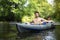 Kayaking along wild river. Two men in boat. Young man with oars in canoe. Leisure on kayak. Active tourism on nature outdoors