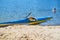 Kayaking concept.Kayak on the beach. Kayak blue and yellow. Boat on the river bank. Summer sunny day. Kayak sport