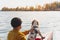 Kayaking with dogs: man sits in a row boat on the lake next to his spaniel.