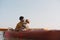 Kayaking with dogs: man sits in a row boat on the lake next to his spaniel.