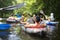 Kayaking. Group of friends relax on canoe in wild river. Sport tourism in jungle river. Leisure activity. Swim in kayak