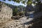 Kayakoy `ghost town` in Lycia, Turkey. Male tourist with backpack standing on stone paved street of abandoned greek village