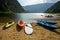 Kayaks, canoes, and other recreational watercrafts lying on the sandy beach while some people are kayaking, canoeing on the Three