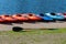 Kayaks lined up on a the bank of a lake
