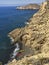 Kayaks on a private beach in the Mediterranean sea. Top down aerial view from the cliffs