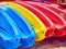 Kayaks stacked on a sandy beach.