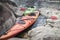 Kayaks stand moored on a rocky seashore.