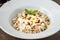 Kayseri ravioli or Kayseri Mantisi on a white plate on wooden table