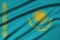 Kazakhstan flag is depicted on a sports cloth fabric with many folds. Sport team banner