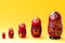 Kazan, Tatarstan, April 28, 2019: Five russian dolls called matreshka in red dresses with lot of floral ornaments on bright yellow
