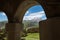 Kazbek 5054m mountain view with Gergeti village through the architectural arches of the chapel in Prophet Elijah Fathers Monastery