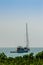 Keel boat moored at shore side, view from forest beach. Seascape