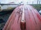 Keel ship of an old fishing boat in focus. Red hull. Background out of focus and in a mist