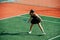 Keen teenage girl playing tennis on a new court, ready to return ball