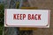 A keep back sign that has been cut in half