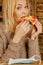Keep calm and bon appetit! Young bold beautiful woman eating pizza without medicine respirator mask. Vertical image