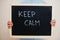 Keep calm. Coronavirus concept. Boy hold inscription on the board