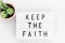 Keep the Faith, text written on a light box. Decorated with cactus