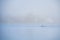 Keep fit rowing a canoe in the mist on a gloomy day. An enthusiast canoeing or kayaking in the fog on a still, calm Baltic sea