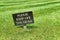 Keep Off The Grass sign on a green lawn