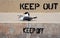 Keep Out and Keep Off sign on a seawall with seagulls