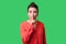 Keep silence! Portrait of elegant woman with bun hairstyle, big earrings and in red blouse. indoor studio shot isolated on green