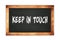 KEEP  IN  TOUCH text written on wooden frame school blackboard