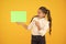 Keep your eye out for the idea. Happy girl pointing finger at certain idea on yellow background. Small cute kid smiling