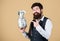 Keep your money in saving bank. Bearded man pointing at glass jar with money cash. Businessman showing his money saving