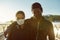 Keep yourself active during the quarantine. Young african couple wearing face medical mask while running together on the