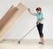 Keeping the house clean takes super strength. Strong young woman lifting a couch and washing the floor beneath it.