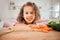 Keeping my vision clear. a little girl eating carrots at home.