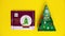 Kehl, Germany - December 4, 2021: A bar of chocolate and a Christmas tree-shaped holiday box suddenly appear on a yellow
