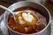 Kelle Paca soup in a bowl / plate with spoon and lemon on wooden table.